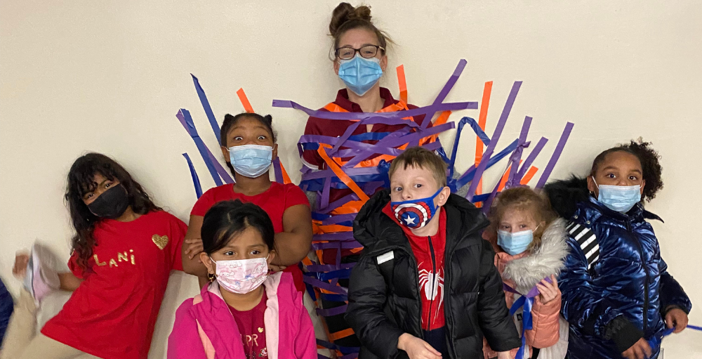 Utica Academy of Science elementary school students tape the Utica Academy of Science Dean to the wall as the ultimate prize in their donation to the American Heart Association’s Kids Heart Challenge.