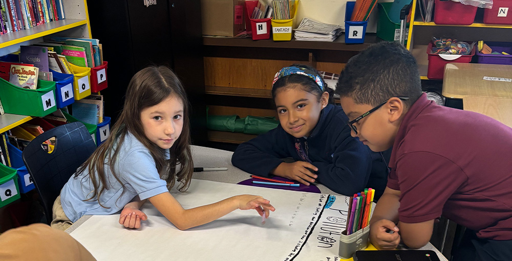 UASCS 4th grade students in Mrs. Marrotta’s Environmental Studies class working together on projects about pollution, extinction, and food waste